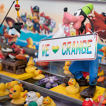 Een foto van eendenvissen bij de Cranger Kirmes: een stripfiguur draagt een bord met de tekst “We love Crange”.