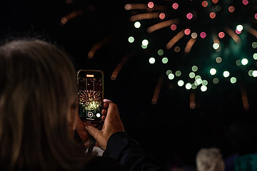 Het legendarische vuurwerk bij de Cranger Kirmes wordt gefilmd door een vrouw met haar mobiele telefoon.